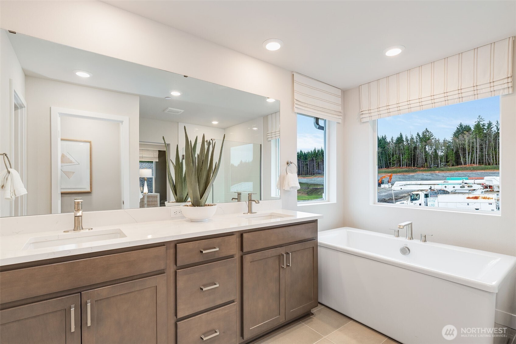 23338 Arbors Ter Road Northeast, Unit 201 Kingston, WA 98346 - Photo 13 of 17 a bathroom with a double vanity sink a large mirror and a bathtub
