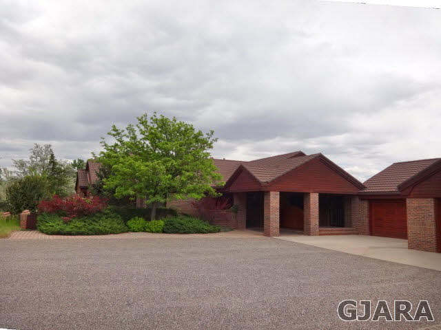 855 25 Road Grand Junction, CO 81505 - Photo 1 of 41 a front view of a house with a yard and garage