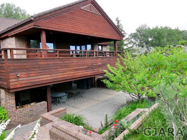 855 25 Road Grand Junction, CO 81505 - Photo 19 of 41 a backyard of a house with table and chairs under an umbrella