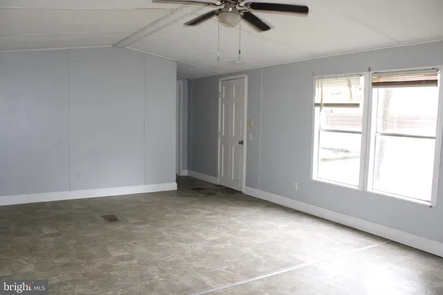 a view of a livingroom with a ceiling fan and window