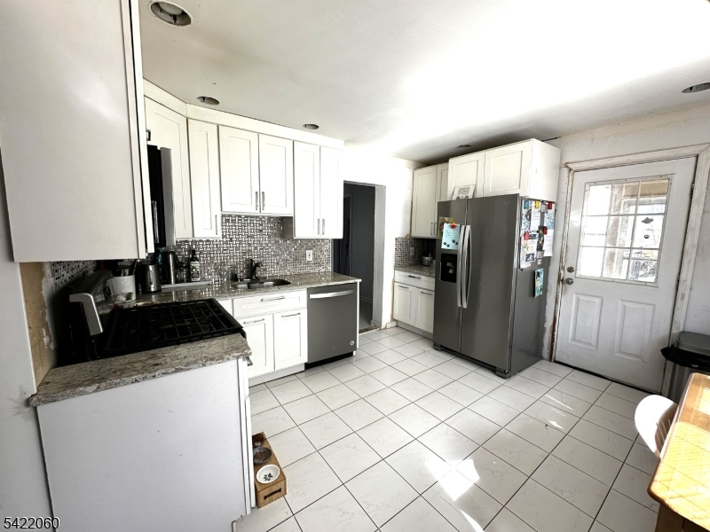 126 Bartholdi Avenue Butler, NJ 07405 - Photo 16 of 22 a kitchen with a refrigerator sink and cabinets