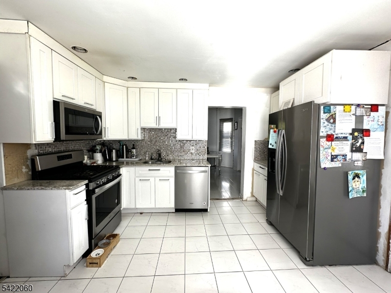 126 Bartholdi Avenue Butler, NJ 07405 - Photo 18 of 22 a kitchen with a sink a microwave a refrigerator and cabinets