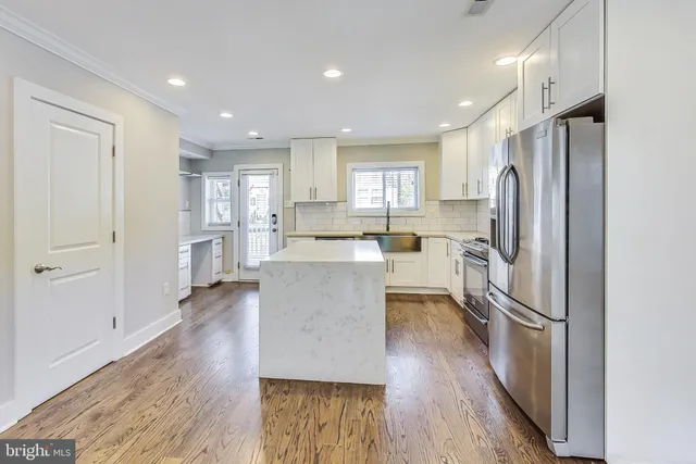 a kitchen with a refrigerator a sink and cabinets