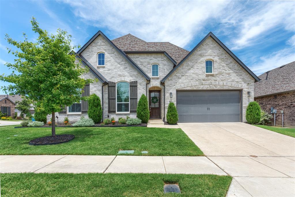 9401 Surveyor Road Oak Point, TX 75068 - Photo 1 of 1 French provincial home with concrete driveway, a front yard, stone siding, and brick siding