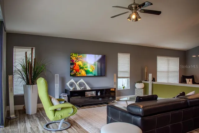 a living room with furniture a wooden floor and a flat screen tv