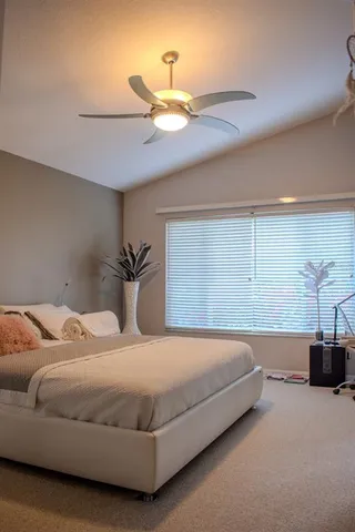 a bedroom with a bed and ceiling fan