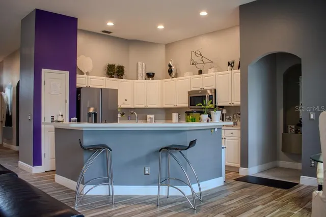 a kitchen with stainless steel appliances granite countertop a refrigerator and a stove top oven