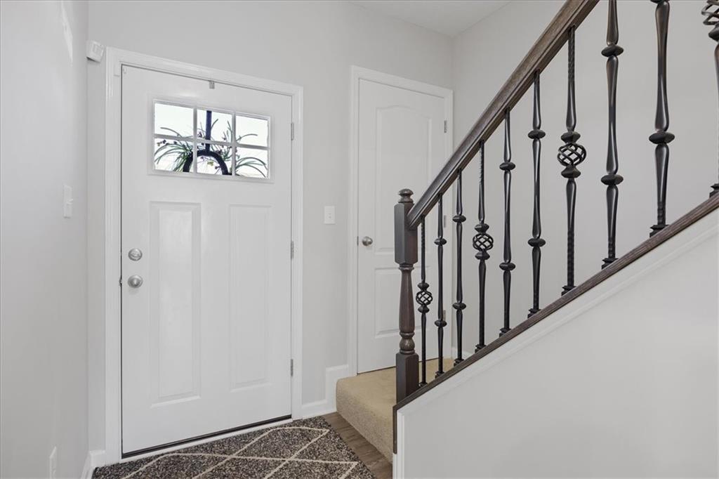233 Wyncrest Drive Butler, PA 16001 - Photo 2 of 25 a view of staircase with lots of frames on wall and a window