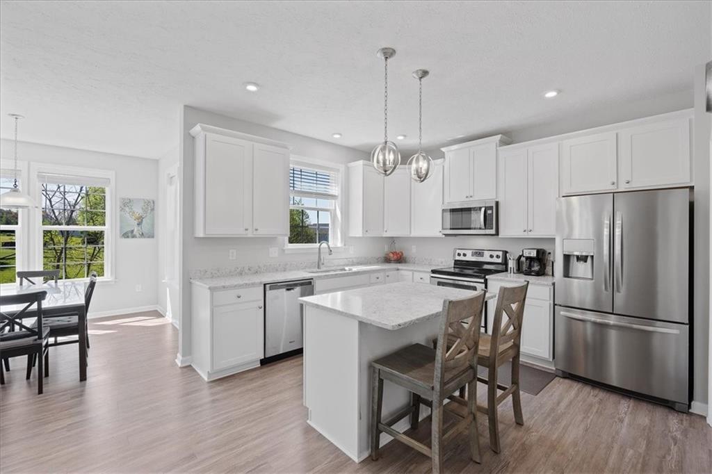 233 Wyncrest Drive Butler, PA 16001 - Photo 5 of 25 a kitchen with stainless steel appliances a dining table chairs stove refrigerator and cabinets