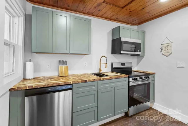 a kitchen with stainless steel appliances granite countertop a stove a sink and a microwave