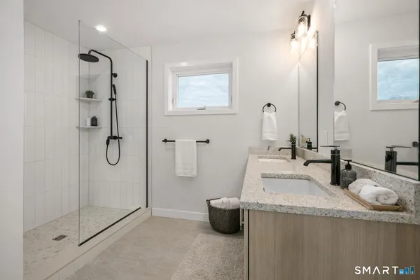 a bathroom with a granite countertop sink a shower and a mirror