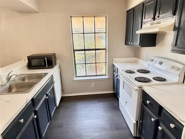 a kitchen with a stove a sink and a microwave