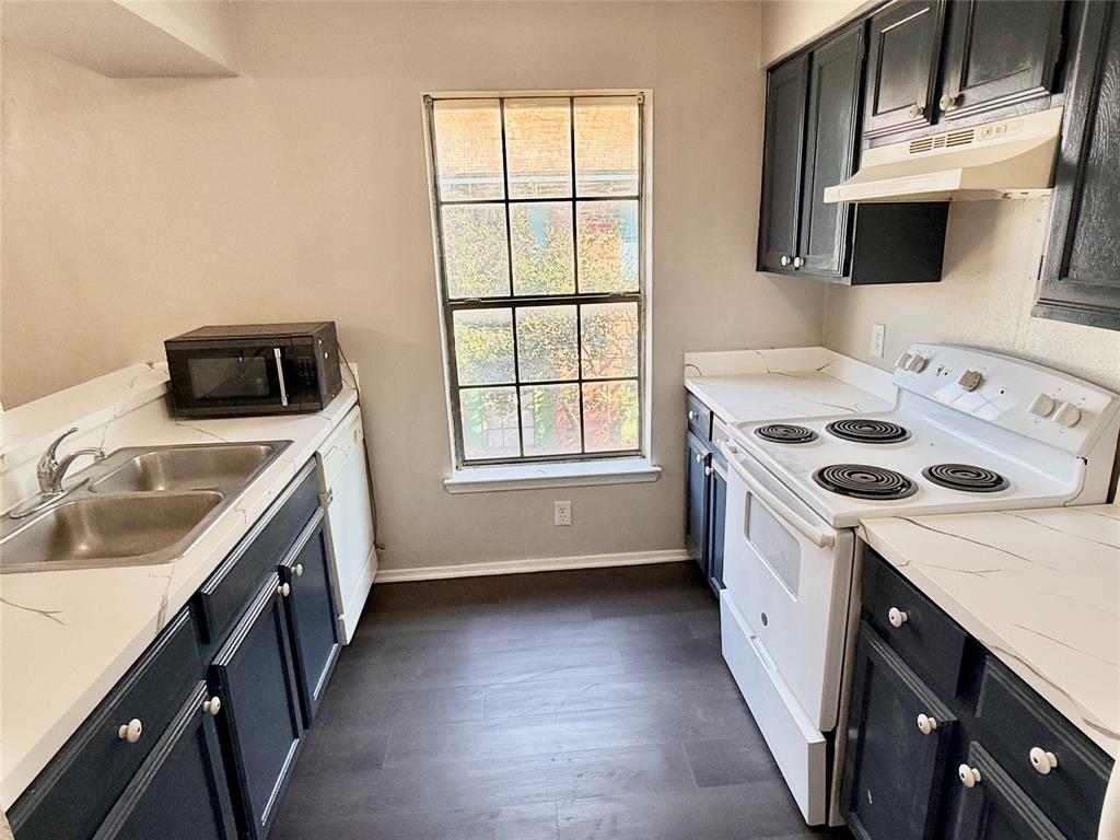 2221 Stella Street, Unit 4 Denton, TX 76201 - Photo 6 of 11 a kitchen with a stove a sink and a microwave