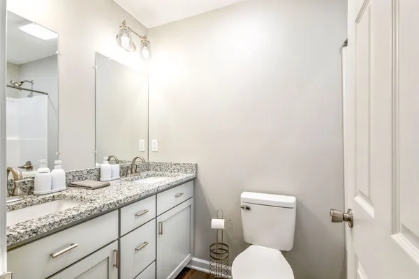 a bathroom with a granite countertop toilet sink and mirror