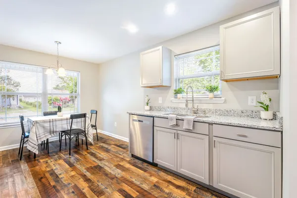 a kitchen with granite countertop white cabinets dining table and chairs