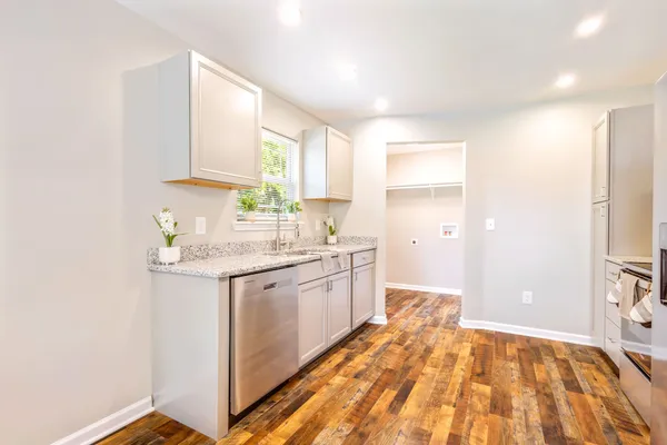 a spacious bathroom with a granite countertop sink and a mirror