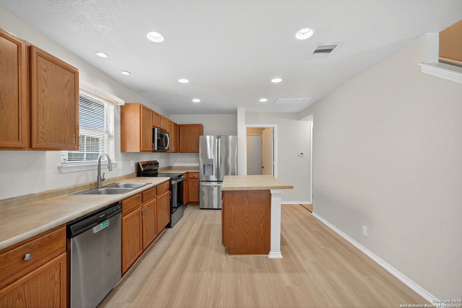 7719 Mesquite Farm San Antonio, TX 78239 - Photo 11 of 27 a large kitchen with stainless steel appliances granite countertop a lot of counter space and wooden floors