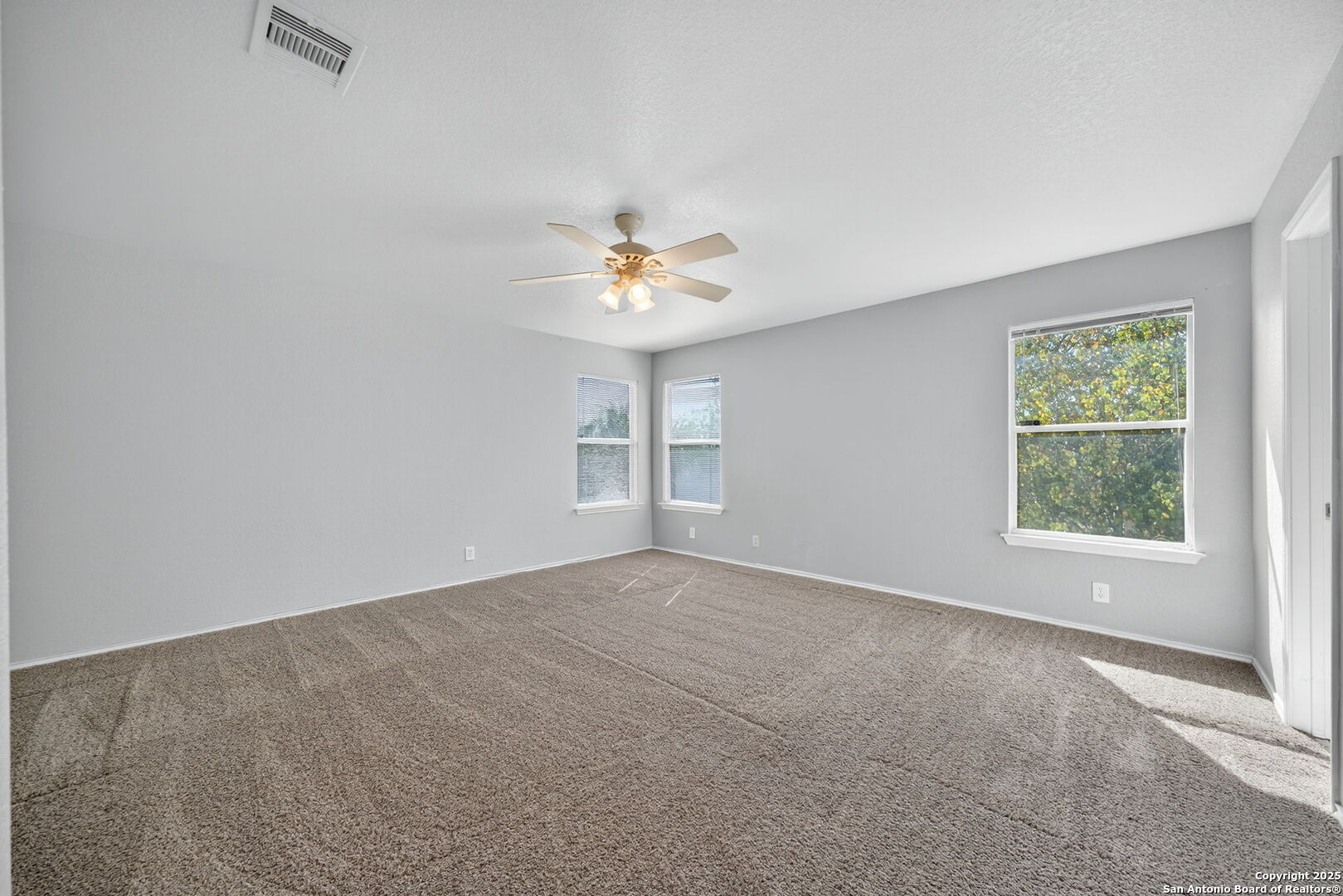 7719 Mesquite Farm San Antonio, TX 78239 - Photo 18 of 27 an empty room with windows and chandelier fan