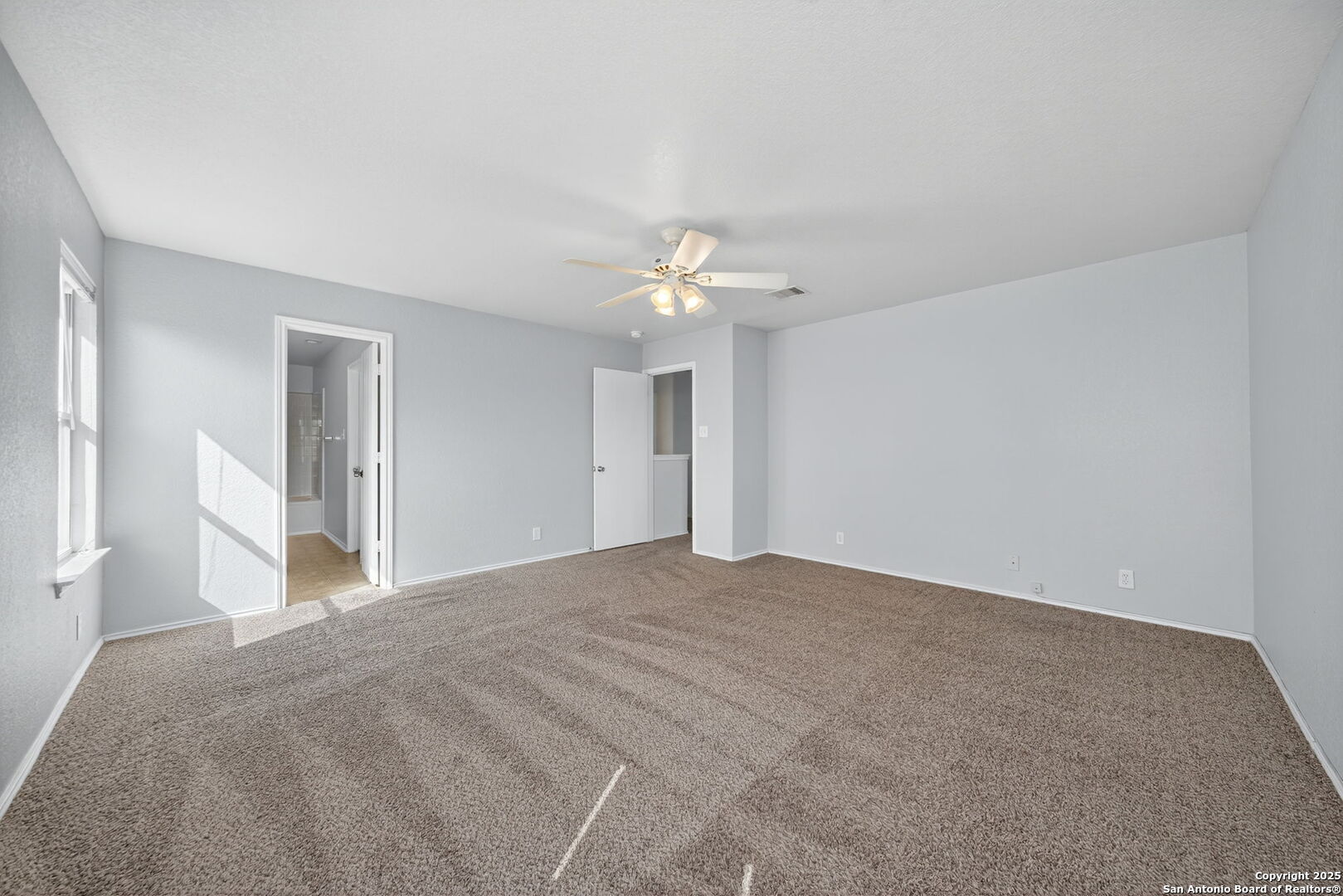 7719 Mesquite Farm San Antonio, TX 78239 - Photo 19 of 27 a view of a big room with windows and chandelier fan