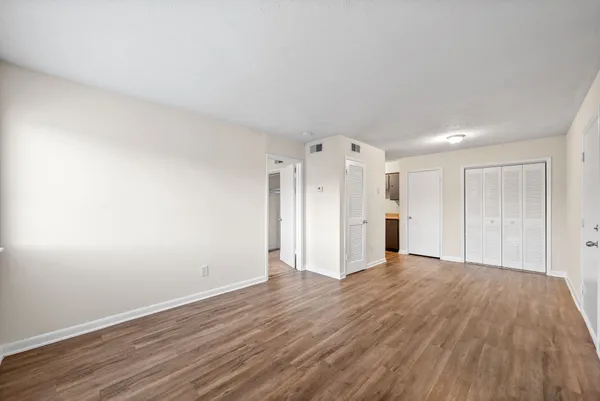 a view of an empty room with wooden floor