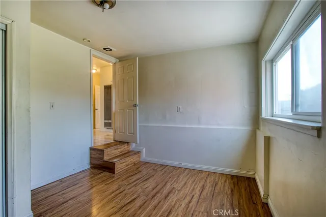 a view of a hallway with wooden floor and closet