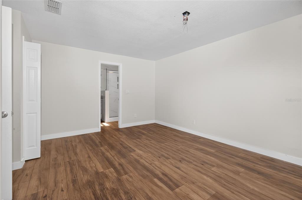 7023 Talbot Drive Orlando, FL 32819 - Photo 16 of 34 a view of an empty room with wooden floor and a ceiling fan