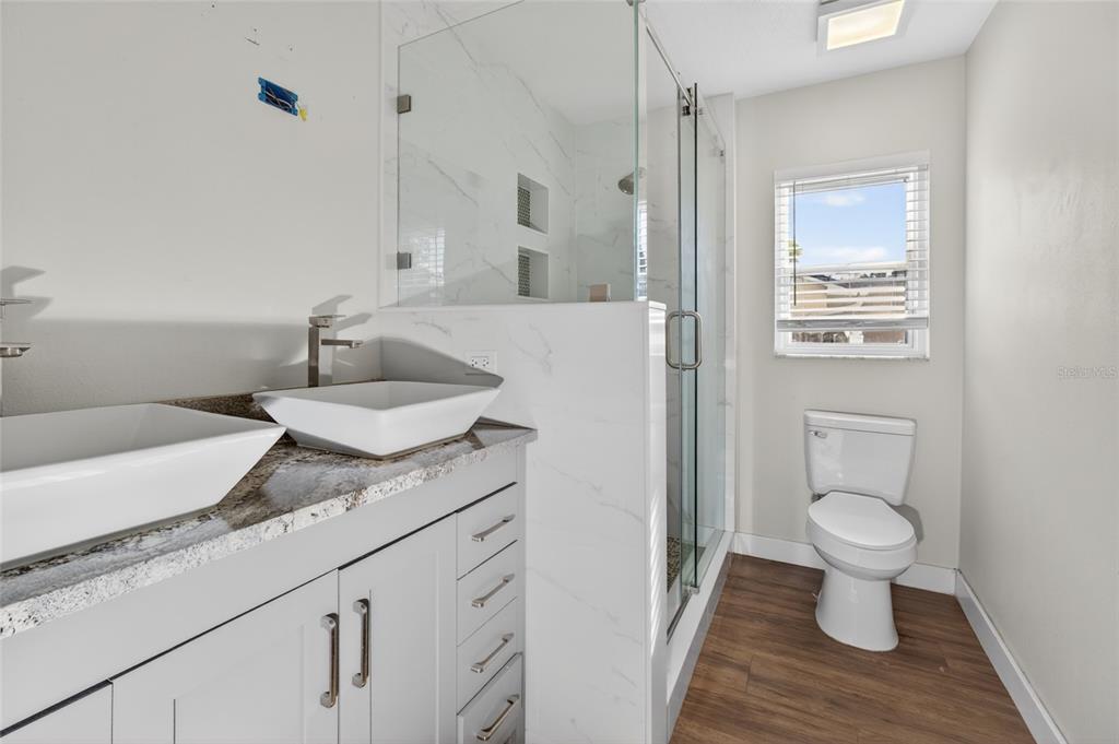 7023 Talbot Drive Orlando, FL 32819 - Photo 17 of 34 a bathroom with a granite countertop sink toilet and a mirror
