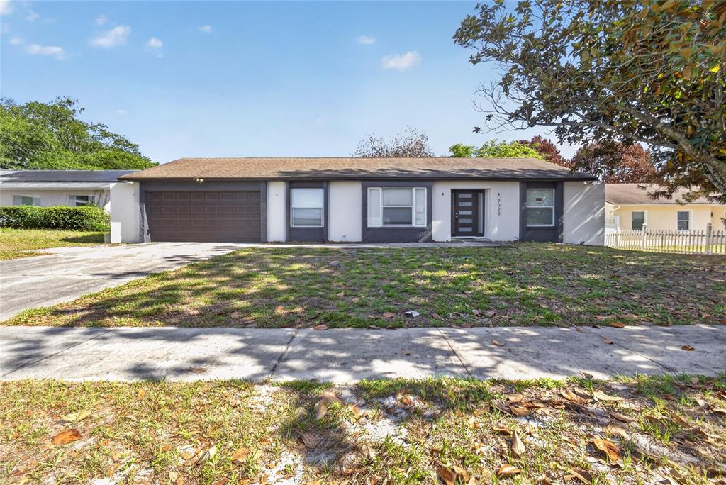 7023 Talbot Drive Orlando, FL 32819 - Photo 2 of 34 a front view of a house with a yard and garage
