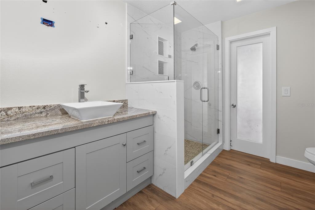 7023 Talbot Drive Orlando, FL 32819 - Photo 22 of 34 a bathroom with a granite countertop sink mirror and shower