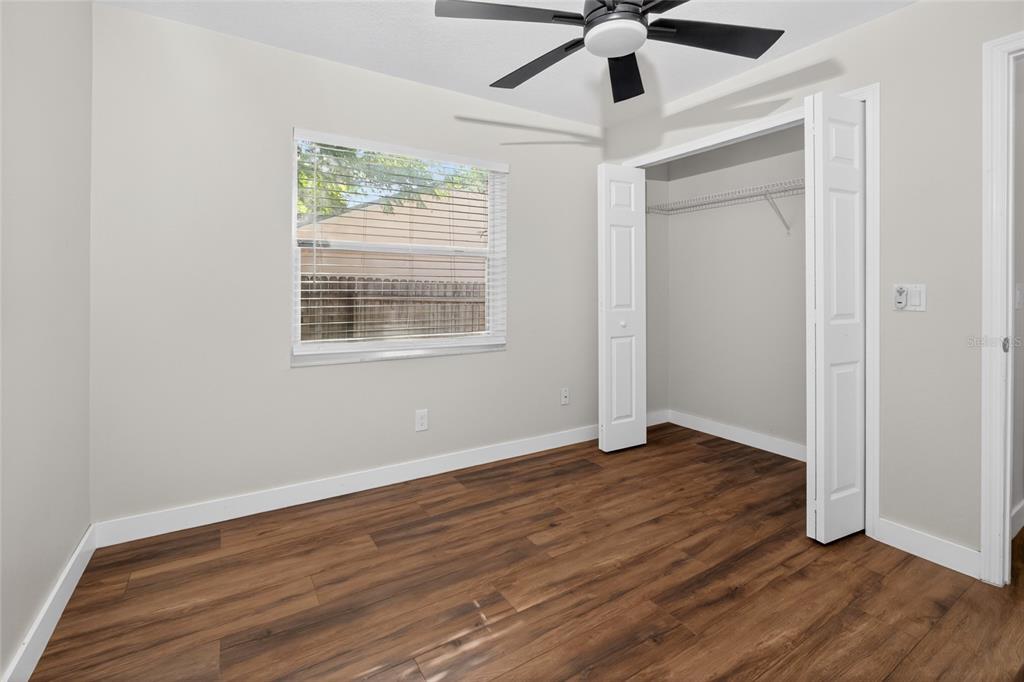 7023 Talbot Drive Orlando, FL 32819 - Photo 23 of 34 an empty room with wooden floor chandelier fan and windows