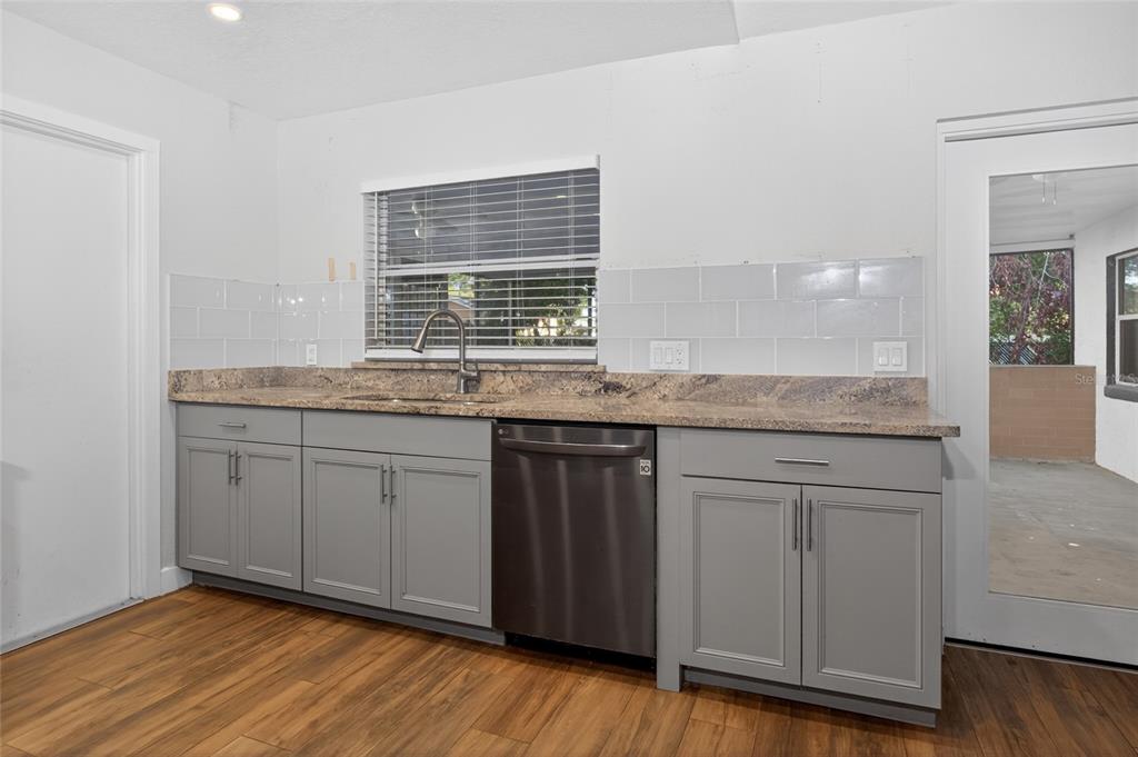 7023 Talbot Drive Orlando, FL 32819 - Photo 8 of 34 a kitchen with granite countertop cabinets and wooden floor