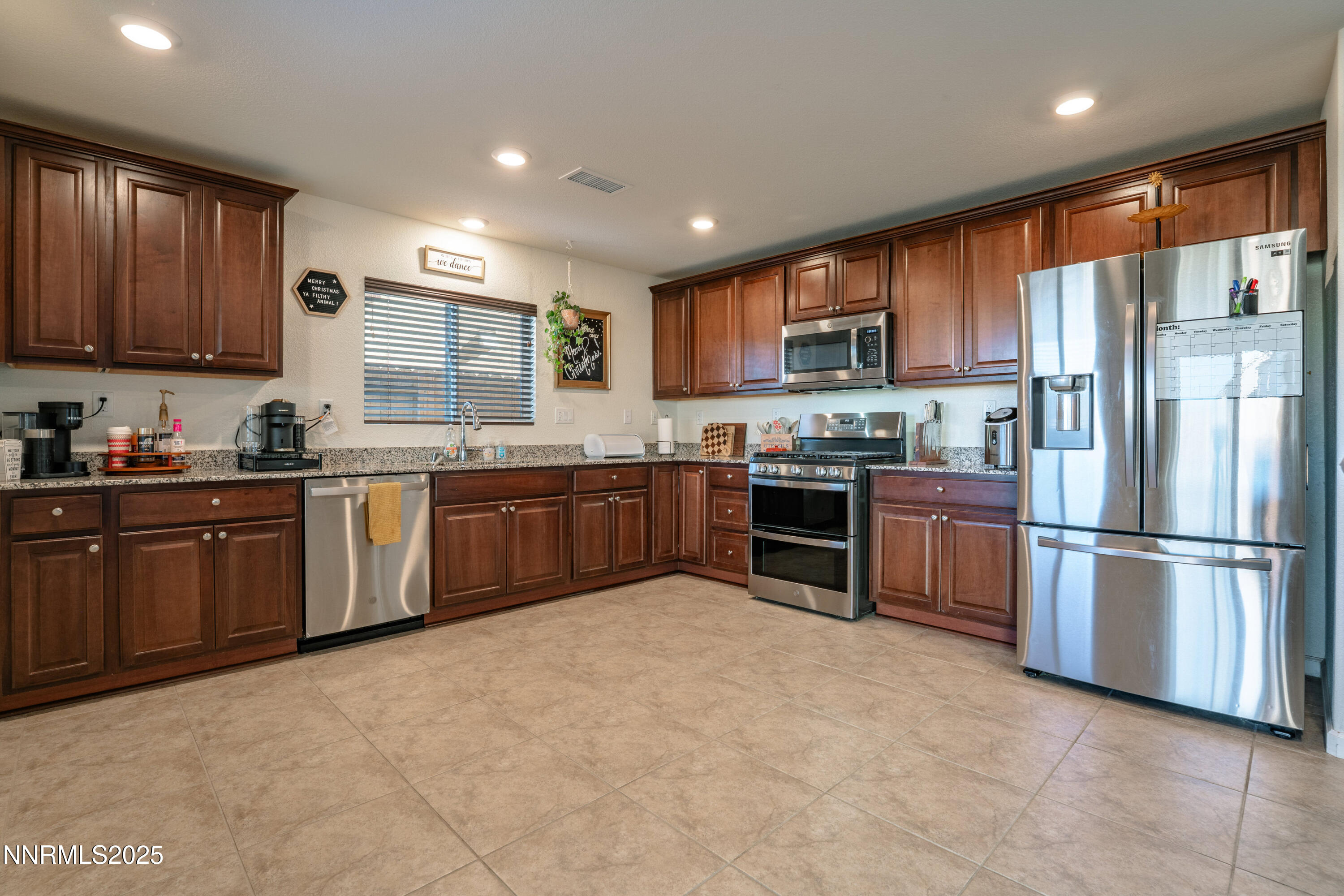 909 Convair Way Reno, NV 89506 - Photo 11 of 42 a kitchen with stainless steel appliances granite countertop a stove sink refrigerator and cabinets