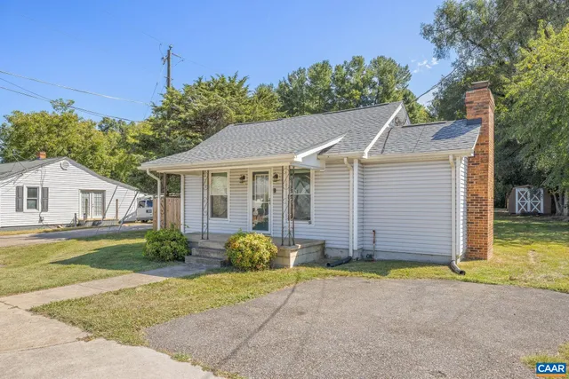 a view of a house with a yard and potted plants