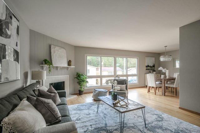 a living room with furniture fireplace and a large window