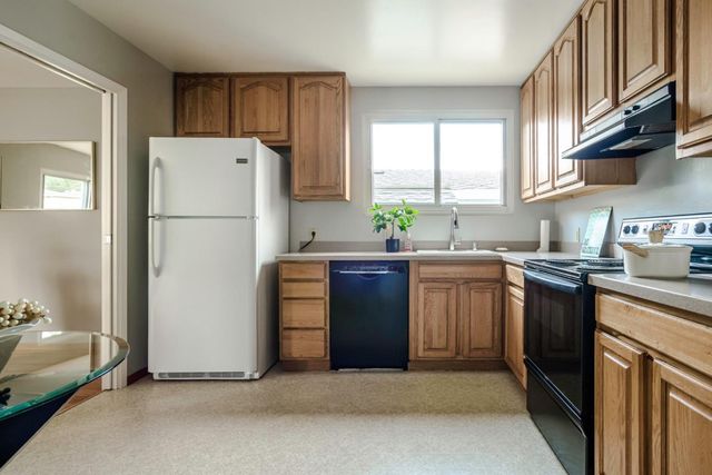 a kitchen with sink a refrigerator and a stove