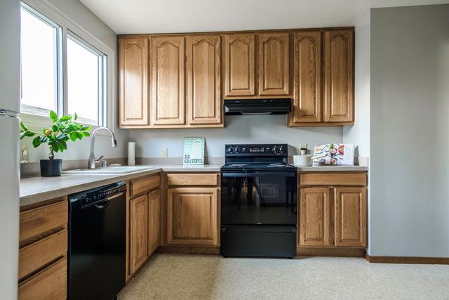 a kitchen with kitchen island granite countertop a sink stainless steel appliances and cabinets
