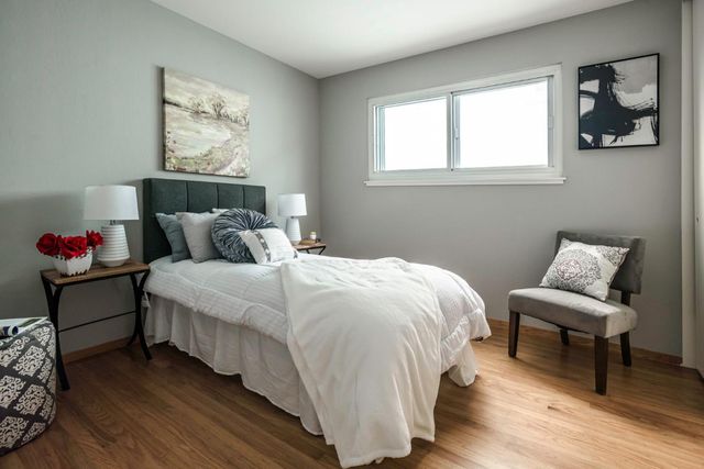 a bedroom with bed and a chair