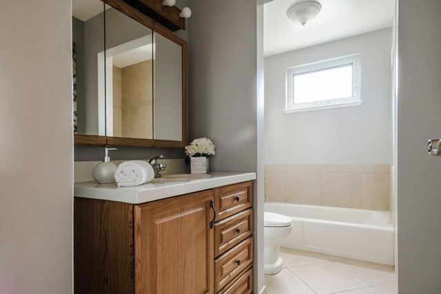 a bathroom with a granite countertop sink toilet and a bathtub