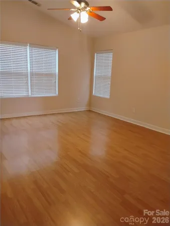 an empty room with windows and fan