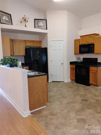 a view of kitchen with a sink microwave and cabinets