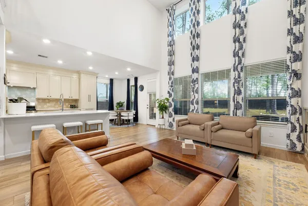 a living room with furniture wooden floor and a large window