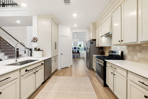 a large kitchen with stainless steel appliances lots of counter space sink and cabinets