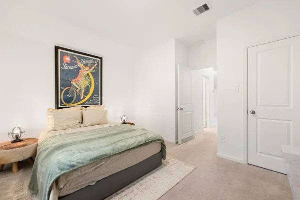 a bedroom with a bed and a painting on the wall