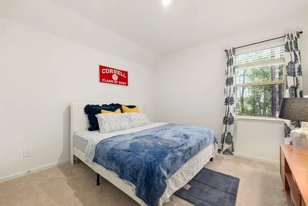 a bedroom with a bed and a large window