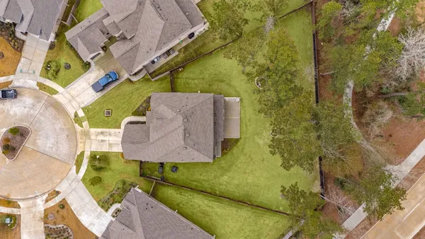 a front view of a house with a garden and trees