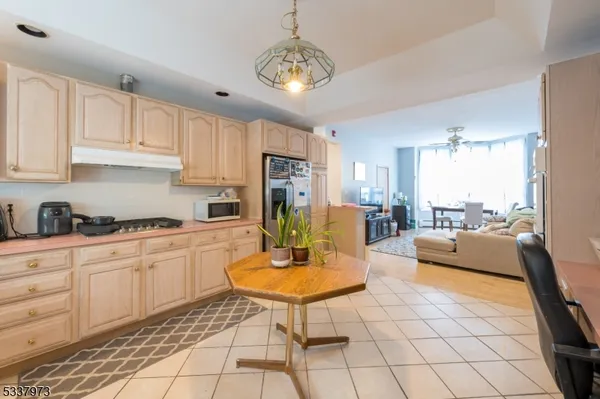a kitchen with stainless steel appliances granite countertop a stove a sink a refrigerator dining table cabinets and living room view