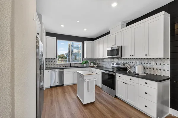 a kitchen with granite countertop white cabinets and white appliances