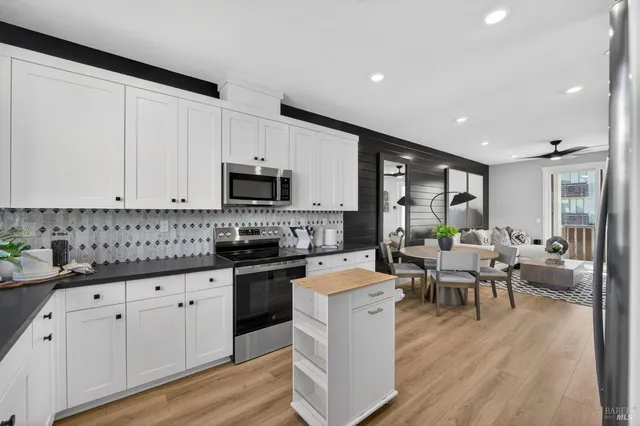 a large white kitchen with lots of counter space a sink and appliances