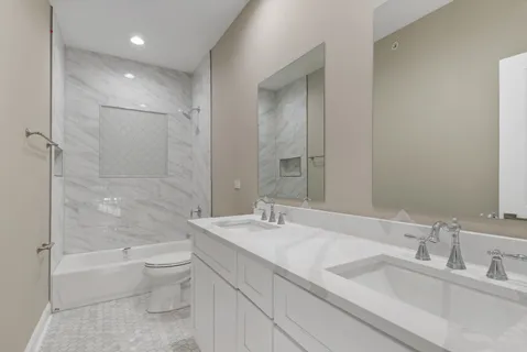 a bathroom with a granite countertop sink a toilet and bathtub