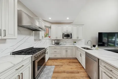 a kitchen with stainless steel appliances a sink stove and cabinets